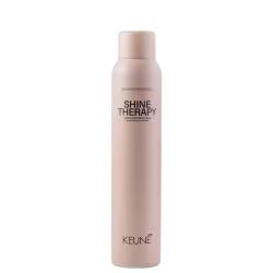 A imagem mostra o produto Shine Therapy da marca Keune. Embalagem cilíndrica na cor bege claro. Rótulo com o nome do produto "Shine Therapy" e descrição "Luminously finishing spray" (Spray de acabamento luminoso) em letras escuras.
