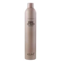 A imagem mostra o spray fixador Keune Free Styler em embalagem cilíndrica de cor bege claro. No frasco está impresso em letras pretas "FREE STYLER 360° freestyling hairspray Laque 360° freestyle". Na parte inferior está escrito "KEUNE" em letras pretas.