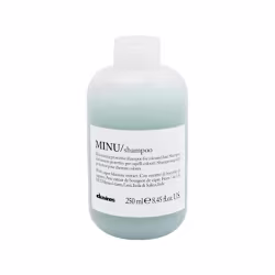Frasco de shampoo Davines Minu, com 250 ml, em embalagem de plástico branco e azul claro, com rótulo informando o nome do produto e sua função de proteção para cabelos coloridos.