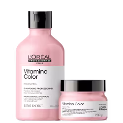 São produtos de cuidado capilar da linha Vitamino Color da L'Oréal Professionnel. Um é um shampoo em um frasco plástico rosa claro de 300ml, com tampa preta. O outro é um tratamento condicionante em um pote rosa claro de 250g, também com tampa preta.