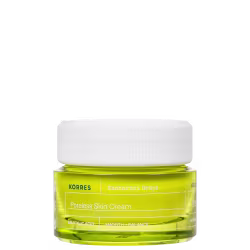 Frasco de creme facial da marca Korres, com rótulo amarelo e branco indicando "Poreless Skin Cream" e "Santorini Grape". O produto contém um líquido de coloração amarelo-esverdeada.