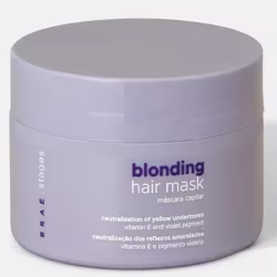 Embalagem circular cinza contendo máscara capilar para loiros, com rótulo indicando "blonding hair mask" e informações sobre neutralização de tons amarelados e pigmentação violeta.