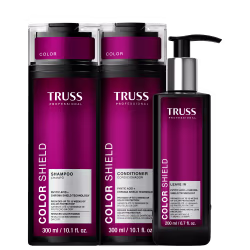 Embalagens de shampoo, condicionador e leave-in da marca TRUSS Professional, com textos "Color Shield" e "Phytic Acid + Chroma Shield Technology" indicando proteção da cor e brilho.