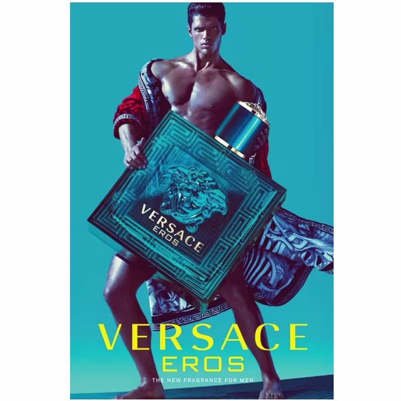 A imagem mostra um cartaz com a propaganda da Versace, com um homem segurando o perfume Eros. Na parte inferior do cartaz, a marca e o nome do perfume estão escritos em amarelo.