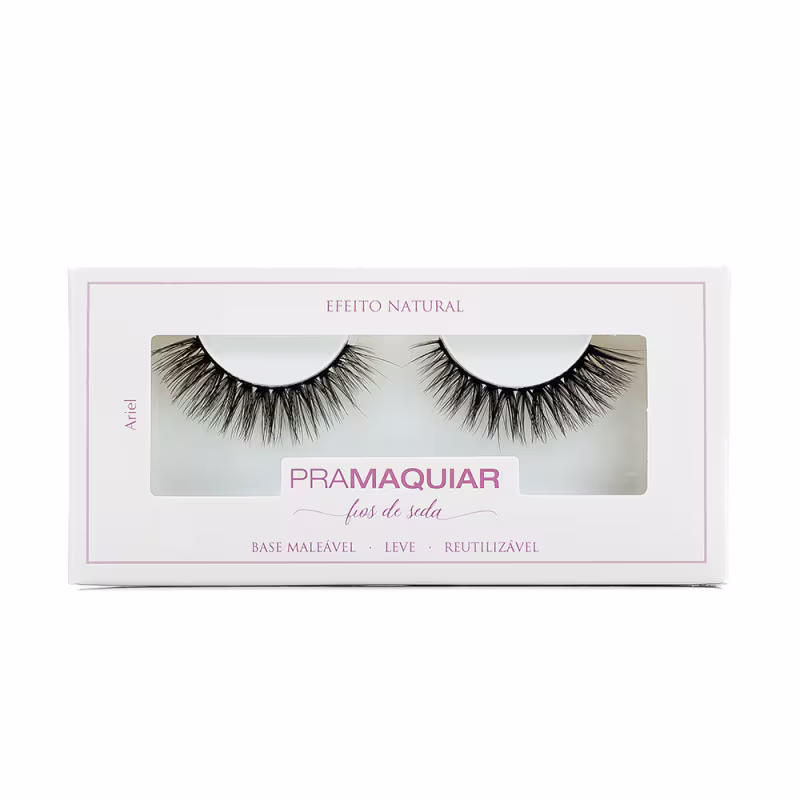 Caixa branca com rótulo "Pramaquiar" contendo um par de cílios postiços pretos em embalagem de plástico transparente. Texto "Efeito Natural" e informações sobre o produto na caixa.