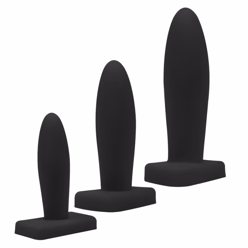 Três plugues anais pretos de diferentes tamanhos e formatos, com superfície lisa e uniforme, apresentados em fundo branco.