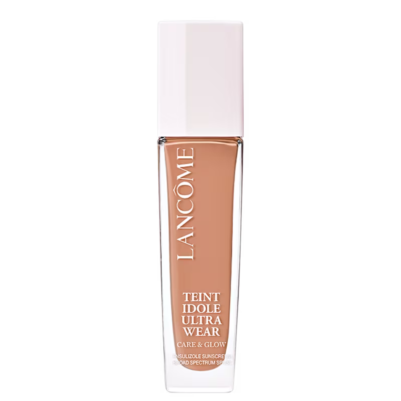 Frasco de maquiagem Lancôme Teint Idole Ultra Wear, com embalagem branca e detalhes em cobre. O produto é descrito como um "Care & Glow" com proteção solar FPS 15.