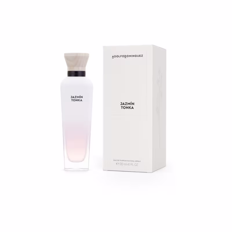 Perfume Jazmín Tonka da marca Adolfo Dominguez. Ao lado do frasco, há uma caixa externa branca com o nome do perfume e da marca em letras pretas. Cores predominantes são branco, rosa claro e preto.
