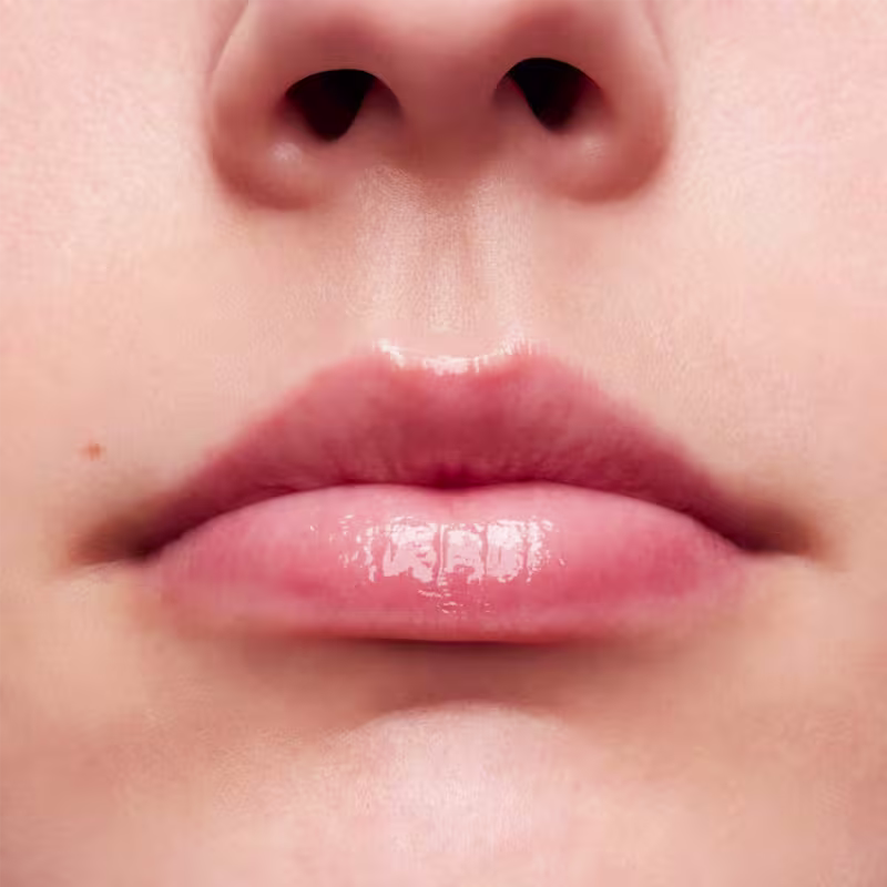 A imagem mostra a boca de uma mulher usando o balm.