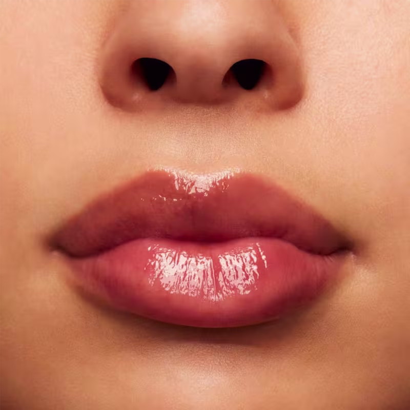 A imagem mostra a boca de uma mulher usando o balm.