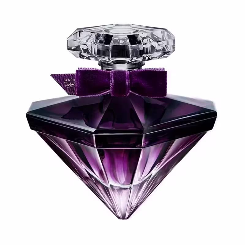 Perfume em frasco de vidro triangular com degradê de roxo escuro a lilás claro. O frasco tem uma tampa de cristal facetada. Uma fita roxa de veludo com o texto "La Nuit Trésor" envolve o gargalo.