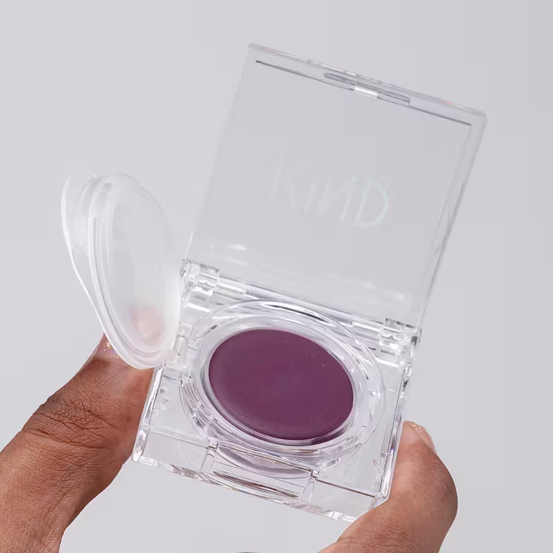 A imagem mostra uma mão negra segurando a embalagem do blush aberta.