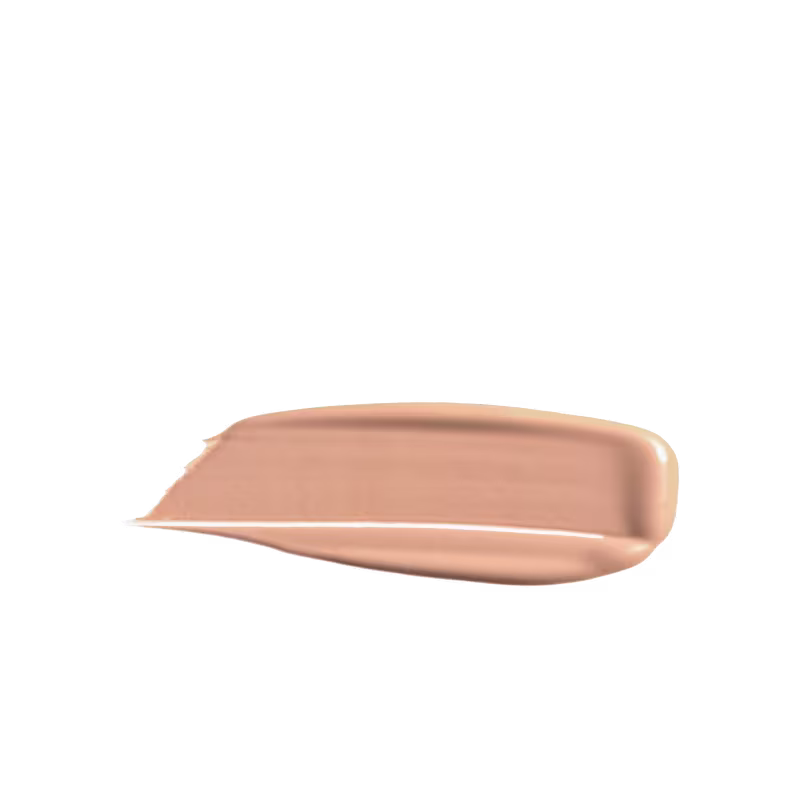 A imagem mostra uma porção de base líquida da marca de maquiagem Wet n Wild, depositada em uma superfície de fundo branco. O produto possui um acabamento brilhante e sedoso, de fácil espalhabilidade.