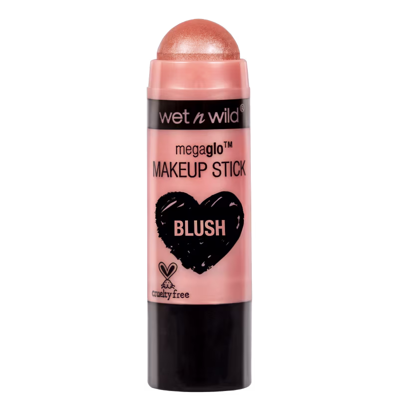 A imagem mostra um produto de maquiagem da marca Wet n Wild. É um blush em bastão com cor rosada. No rótulo, há um coração desenhado em preto com a palavra "Blush" dentro dele. Também está escrito que o produto é cruelty free (não testado em animais).