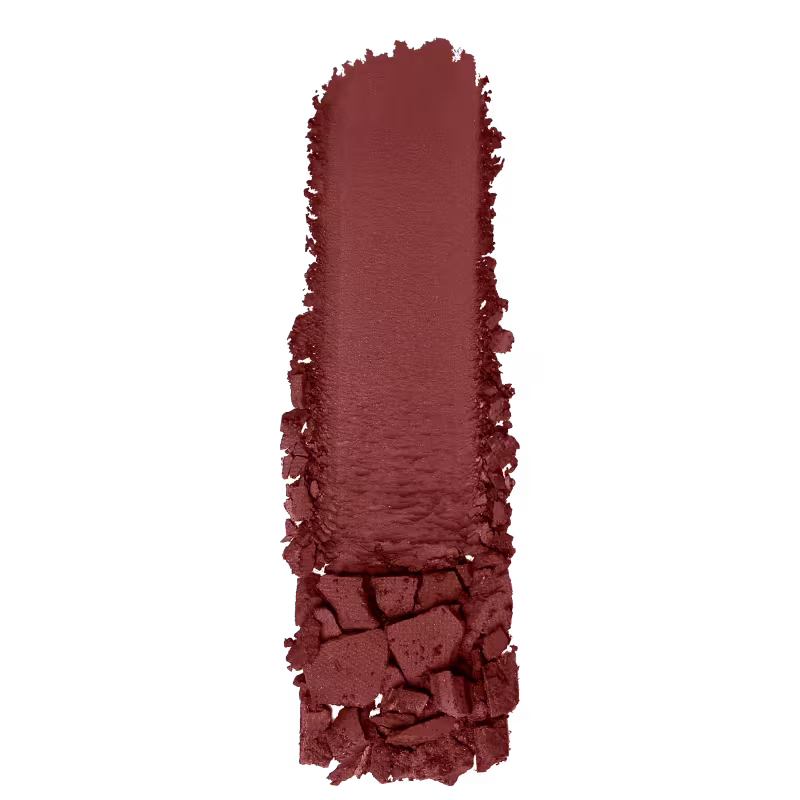 A imagem mostra uma amostra de sombra marrom, da marca Wet n Wild. O produto está depositado em uma superfície branca, a fim de mostrar a sua textura e acabamento.