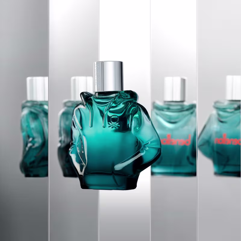 Frasco do perfume em um ambiente espelhado com 4 reflexos do produto ao redor.