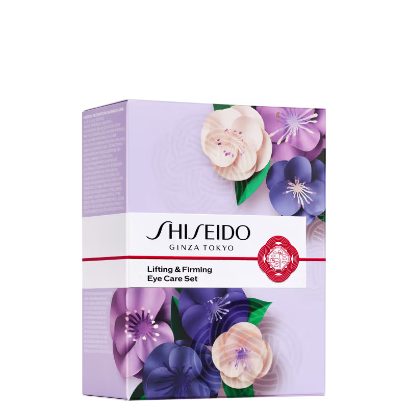 Caixa de papelão branca com detalhes florais em tons de roxo, azul e bege. O logotipo "Shiseido Ginza Tokyo" e o texto "Lifting & Firming Eye Care Set" estão visíveis na parte frontal da embalagem.