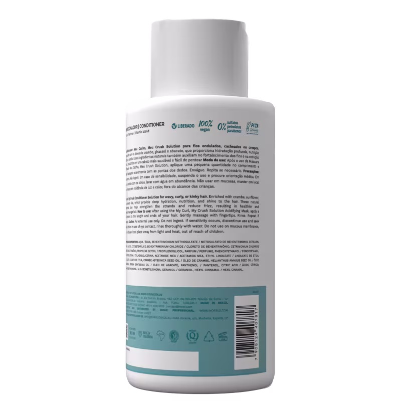A imagem mostra a parte de trás do Condicionador Meu Cacho, Meu Crush Solution. Contém a lista de ingredientes, informações do fabricante, código de barras e instruções de uso. Produto vegano e sem conservantes, conforme indicado nos símbolos.