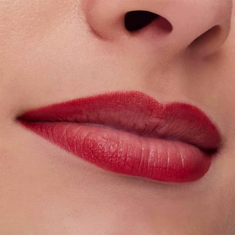 A imagem mostra a boca de uma mulher usando o lápis de boca.