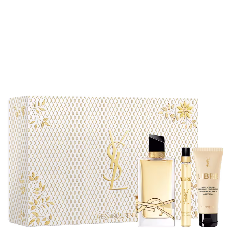 A imagem mostra o conjunto de produtos da linha Libre de Yves Saint Laurent. Mostra o frasco do perfume Libre de 90ml, a versão em miniatura e uma loção corporal de 50ml. Ao lado mostra a caixa especial, branca com detalhes texturizados dourados.
