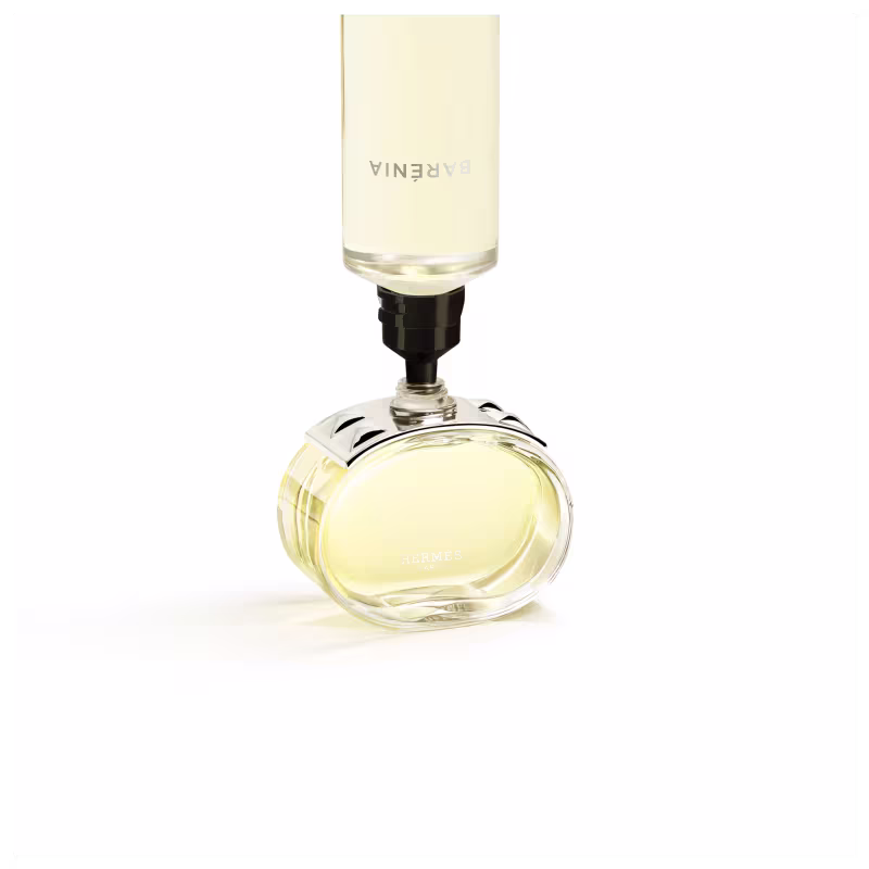 Perfume em frasco de vidro transparente com detalhes cromados sendo preenchido pelo seu refil.