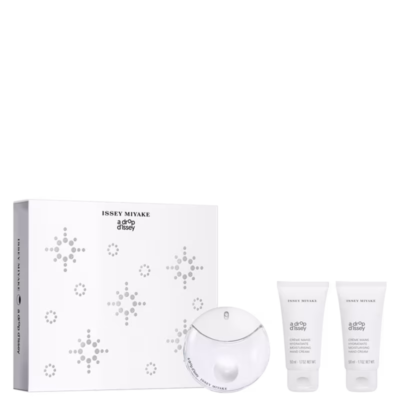 Caixa branca com padrão de bolinhas em tons de cinza. Contém um perfume em frasco redondo branco com tampa e dois tubos de creme para as mãos.