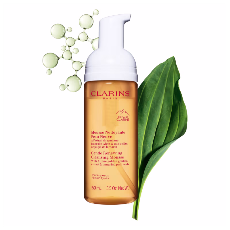 A imagem mostra o frasco do mousse com algumas plantas verdes.