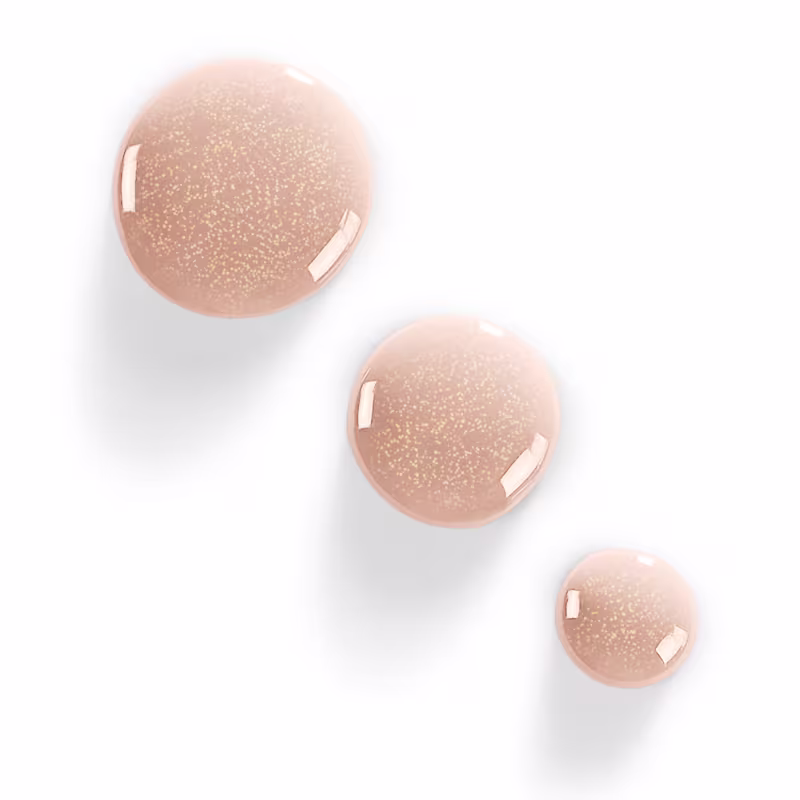 3 gotas do esmalte sobre uma superfície plana, com foco na cor e brilho do produto.