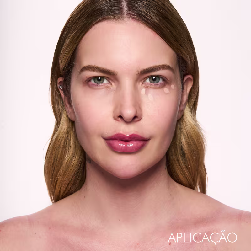 A imagem mostra uma modelo fazendo a aplicação do corretivo.