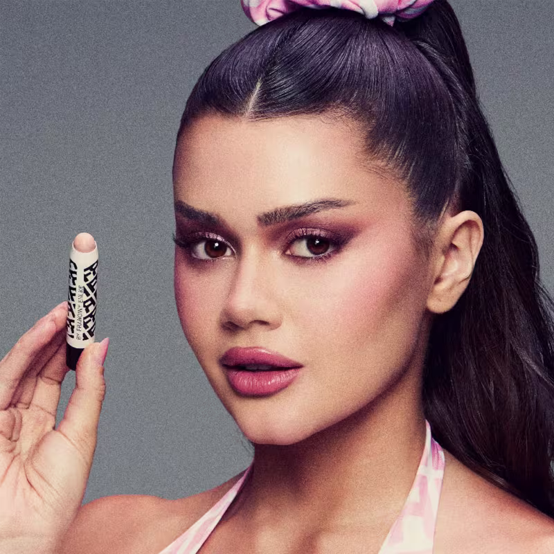 A imagem mostra uma modelo com o corretivo na mão.