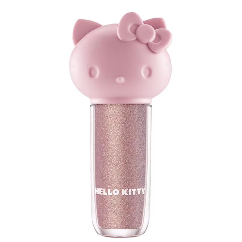 Maquiagem em formato cilíndrico com a cabeça da personagem Hello Kitty como tampa. A parte superior é rosa com detalhes em relevo que representam os olhos, orelhas e laço da Hello Kitty. É possível ver a cor do produto pelo corpo transparente.