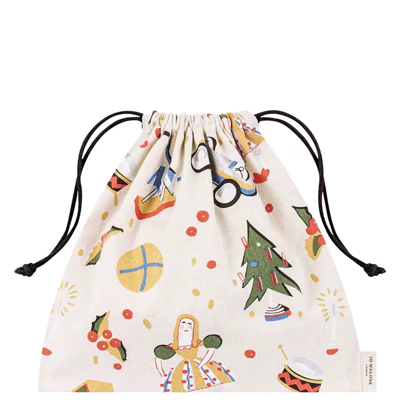 A imagem mostra um saco de cordão de pano com um padrão alegre e colorido. O tecido é branco com ilustrações que lembram o clima natalino. As estampadas possuem tons de amarelo, verde, azul e laranja.