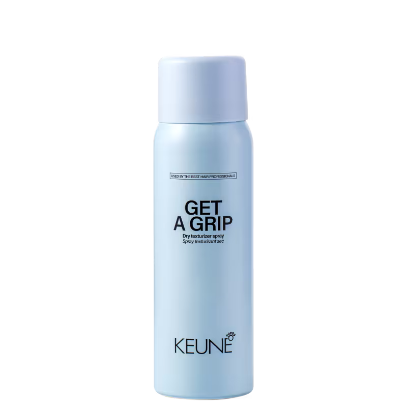 A imagem mostra o produto Keune Get a Grip. Embalagem cilíndrica azul claro. Nome do produto "Get a Grip Dry texturizer spray" e logotipo da Keune em letras pretas.