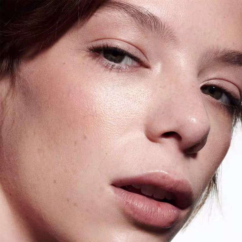 A imagem mostra uma modelo com a pele clara e o efeito de cor do Blush Líquido M·A·C Strobe Starlite