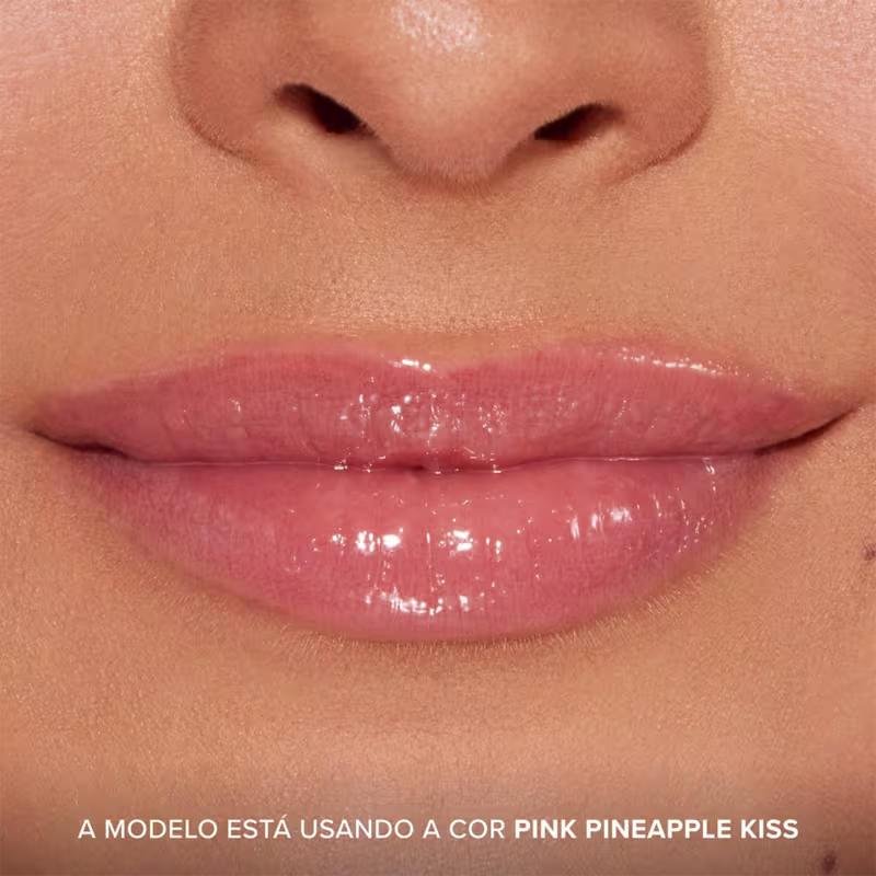 A imagem mostra o resultado do uso do Lip Treatment Too Faced Pillow Balm, com foco nos lábios. Frase: A modelo está usando a cor Pink Pineapple Kiss