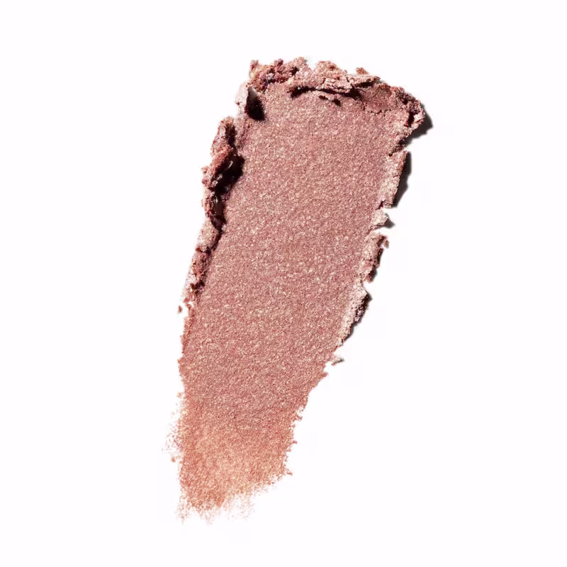 Textura cremosa e sedosa de um produto de maquiagem da marca M·A·C, com tonalidade marrom acobreada e acabamento aveludado.