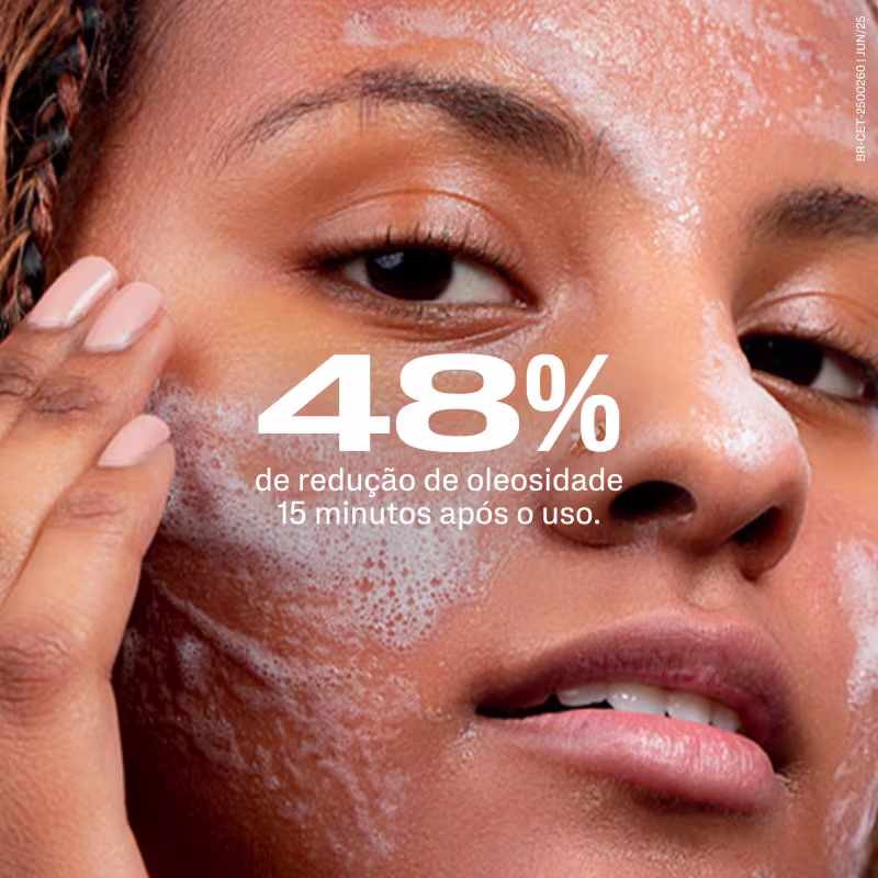 Imagem mostra rosto de pessoa com mãos próximas ao rosto, com a espumar produzida na limpeza. Texto sobreposto indica 48% de redução de oleosidade 15 minutos após o uso do item.