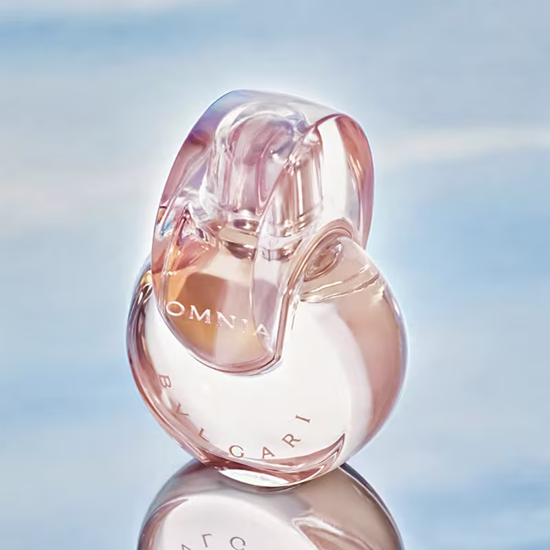 Frasco de perfume Omnia da marca Bvlgari, com formato oval e tampa transparente, exibindo o nome da marca em letras douradas. 