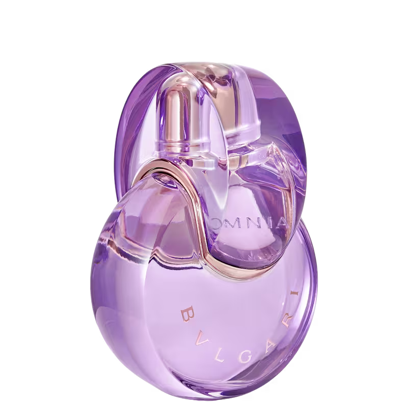 Item de perfumaria em formato oval, com tampa e corpo transparentes em tons de roxo e rosa. O rótulo exibe a marca "BVLGARI" em letras douradas. O produto possui um design elegante e sofisticado.