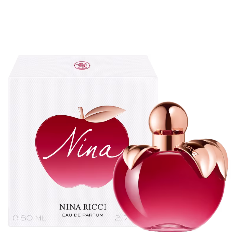 Frasco de perfume em formato de maça, com tampa dourada, em cor vermelha brilhante. Rótulo com nome da marca "Nina Ricci" visível.