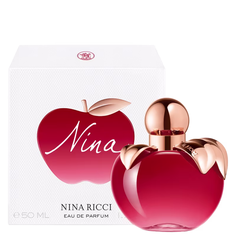 Frasco de perfume em formato de maça, com tampa dourada, em cor vermelha brilhante. Rótulo com nome da marca "Nina Ricci" visível.