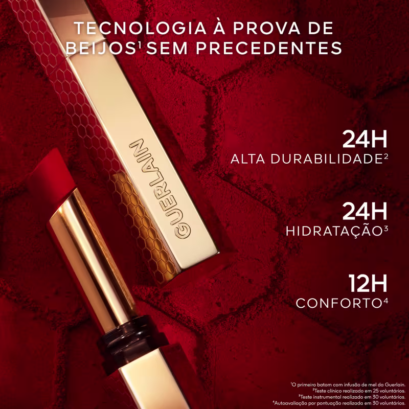 "Tecnologia à prova de beijos sem precedentes" em destaque. Abaixo, são listadas as características do produto, incluindo "24h Alta Durabilidade", "24h Hidratação" e "12h Conforto". A embalagem possui uma textura dourada com padrão hexagonal.