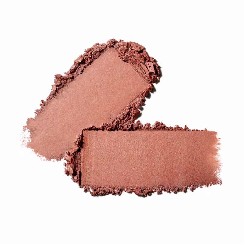 O produto de beleza apresenta uma textura aveludada e macia, com uma coloração marrom acobreada. Sua aparência é uniforme e levemente brilhante, sugerindo uma fórmula cremosa e de boa cobertura.