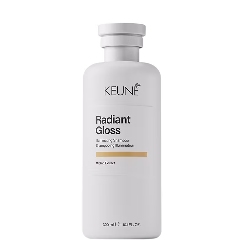 Frasco branco de 300 ml da linha Radiant Gloss da Keune, um shampoo iluminador com extrato de orquídea, com rótulo preto e branco destacando o nome da marca e do produto.