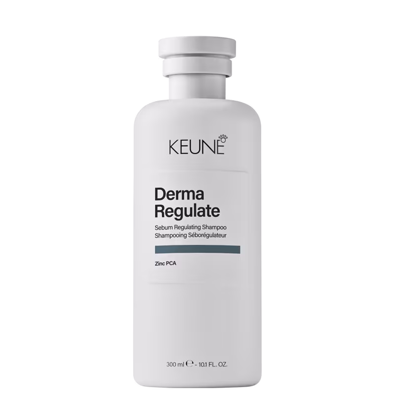 Frasco branco de shampoo Keune Derma Regulate, com rótulo preto e cinza indicando o nome do produto e seu uso para regular a oleosidade do couro cabeludo. Embalagem cilíndrica com tampa branca.