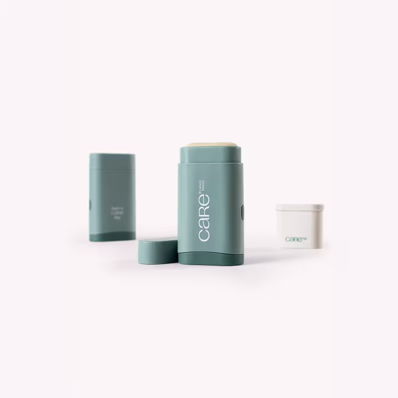 Embalagens de plástico verde-azulado, com o logotipo "Care" visível. Incluem um frasco maior e dois menores, possivelmente contendo itens de cuidados pessoais ou cosméticos.