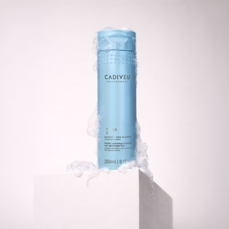 Embalagem azul clara do shampoo Hydra Pro da marca Cadiveu Professional, com textura espumosa e detalhes em relevo, em um ambiente minimalista e branco