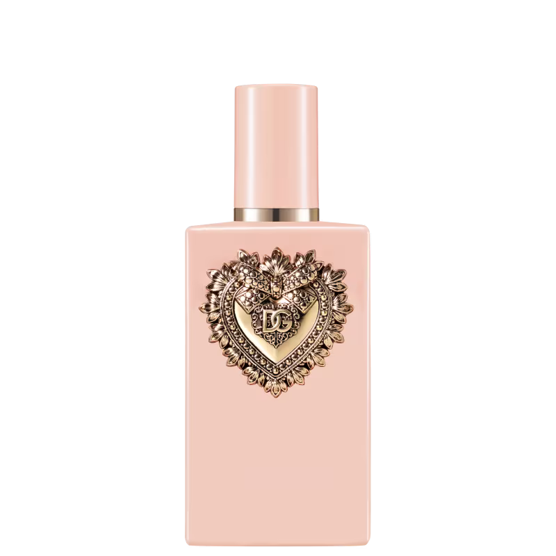 Frasco de item de perfumaria com tampa dourada em formato de coração ornamentado. Embalagem rosa clara com detalhes dourados. 