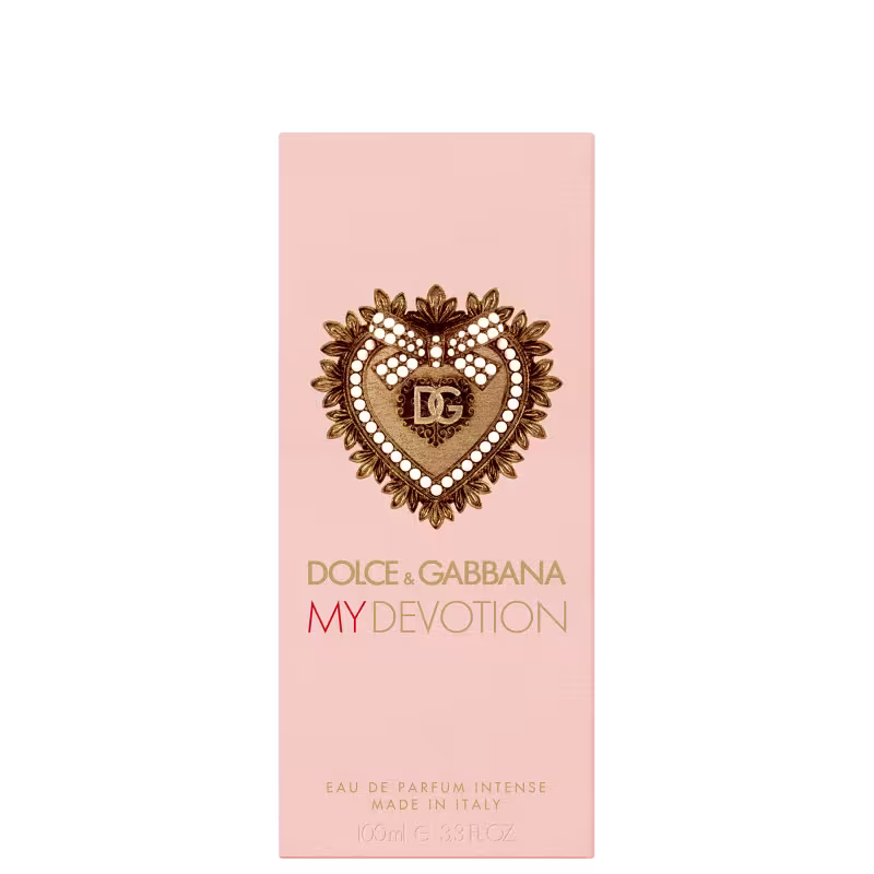 Caixa de item de perfumaria com tampa dourada em formato de coração ornamentado. Embalagem rosa clara com detalhes dourados. 