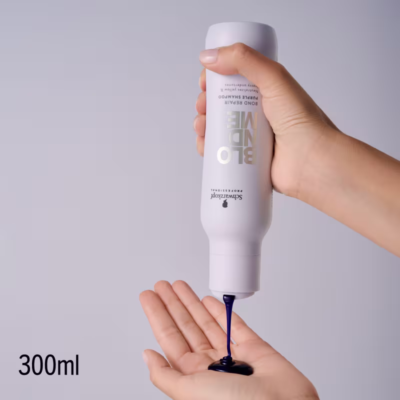 Produto de cuidados capilares da marca Schwarzkopf Professional, em embalagem branca com detalhes em dourado, sendo aplicado em mãos sobre fundo neutro.